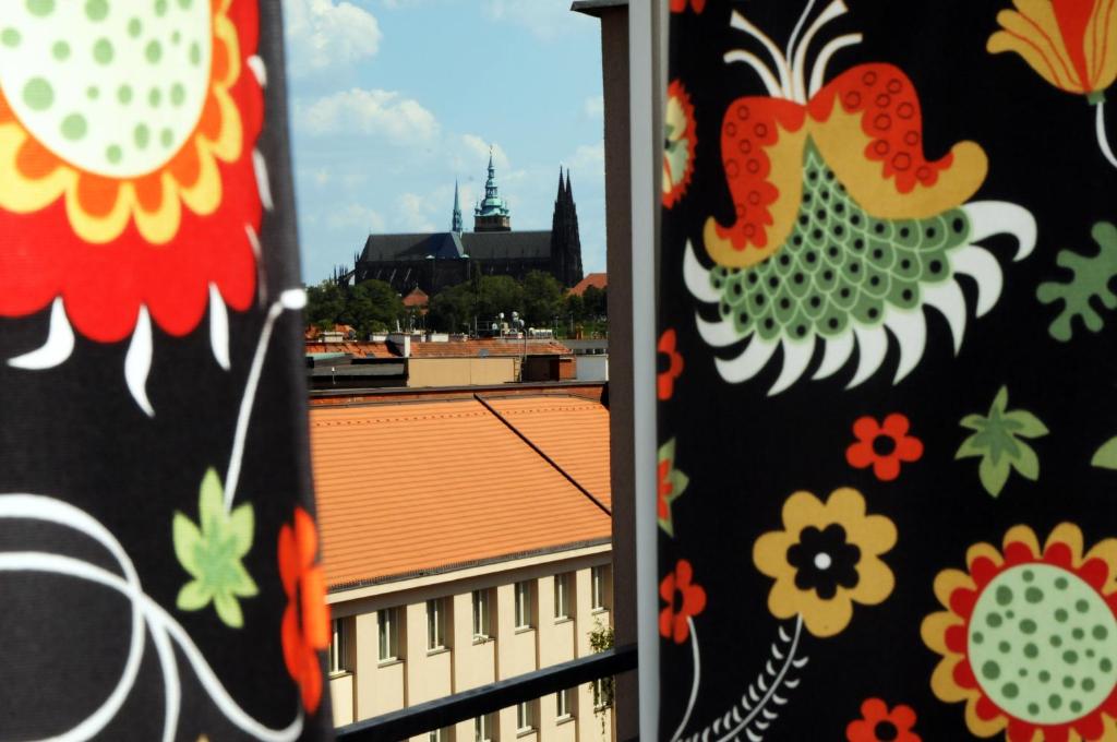 Panorama Prague Castle في براغ: منظر من نافذة مبنى به زهور