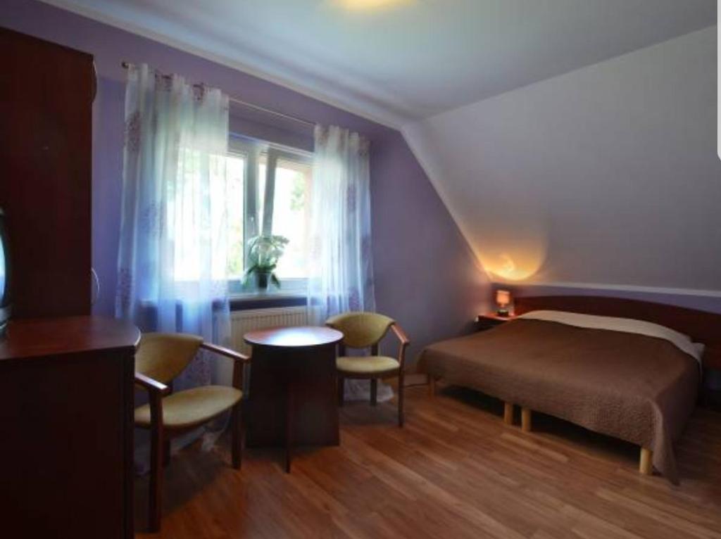 a bedroom with a bed and a table and chairs at Janina in Pobierowo