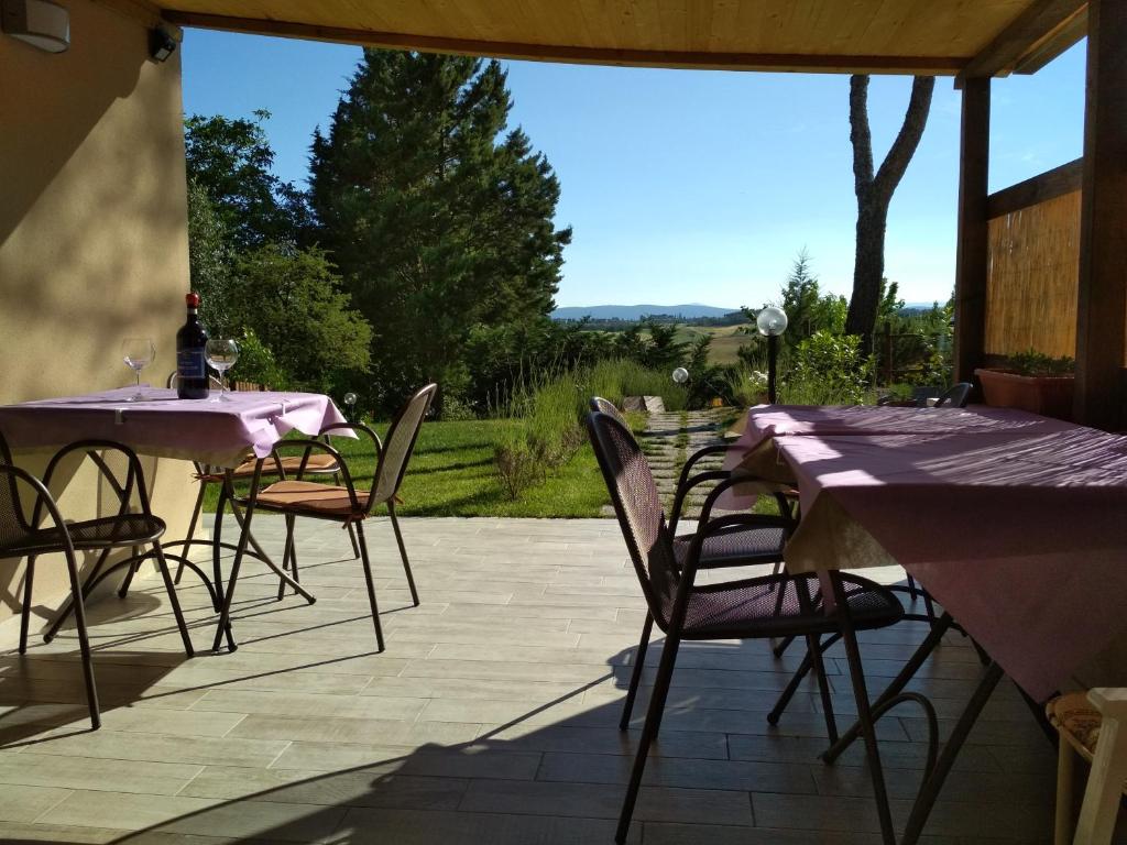 a patio with tables and chairs with a view of a field at Il Lavandeto - farmhouse in the city in Siena