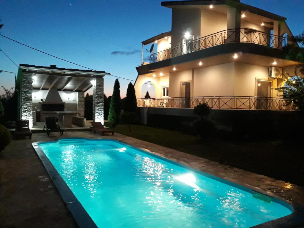 a villa with a swimming pool in front of a house at Villa Oneiro in Kanali