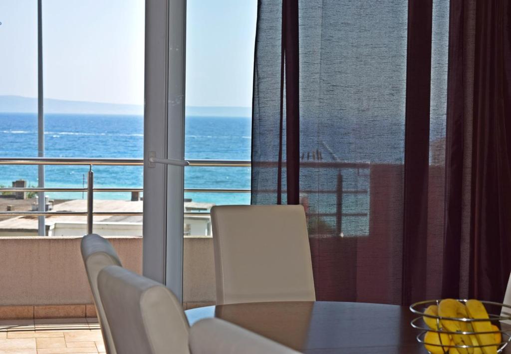 a dining room with a table and a view of the ocean at Apartments Andrea in Podstrana