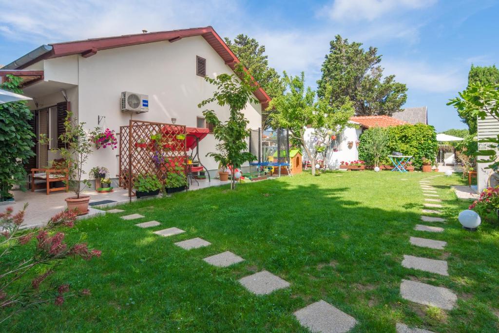 a garden with a lawn and a house at Apartments Kiara Sabunike 836 in Privlaka