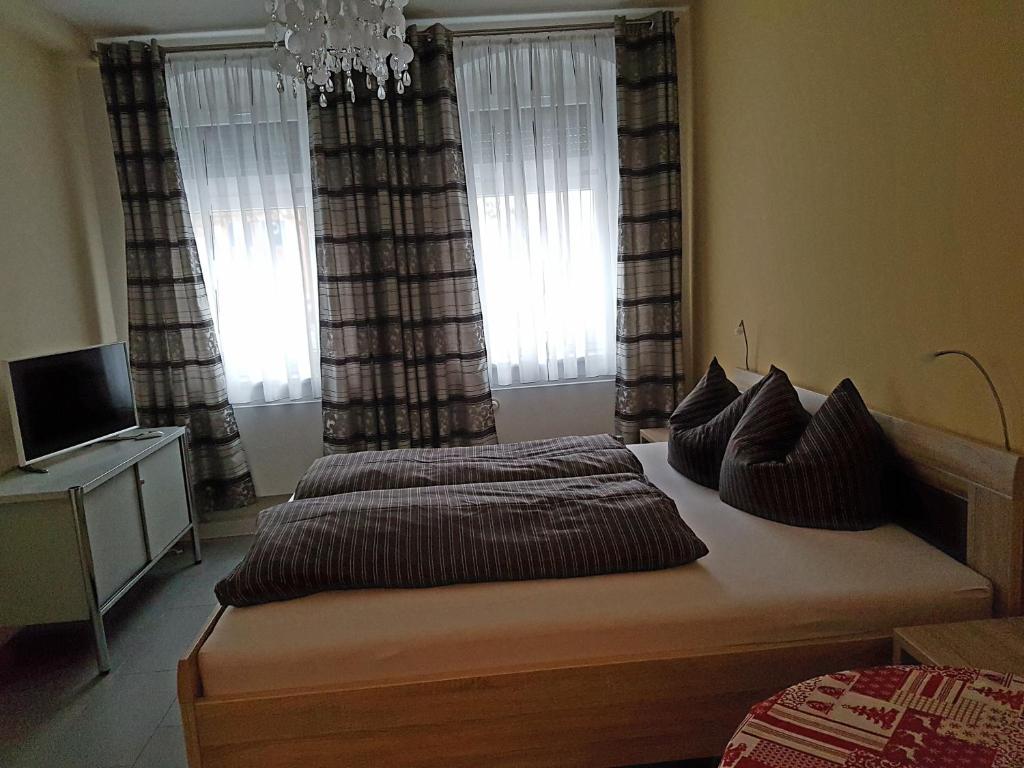 a bedroom with two beds and a television and windows at Ferienoase in Pirna