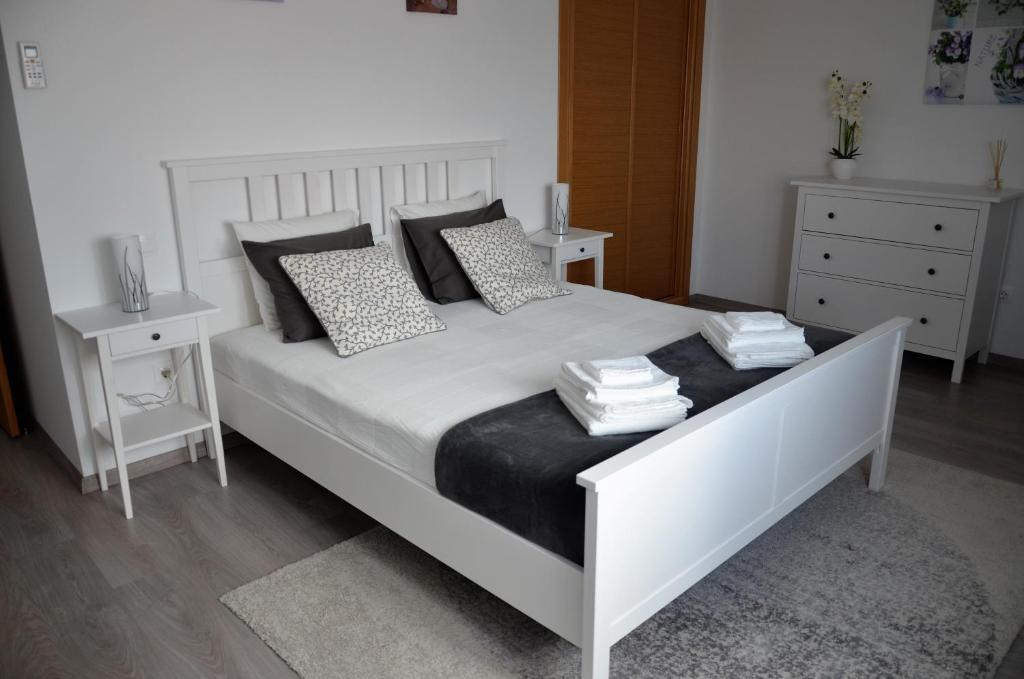 a bedroom with a large white bed with pillows at Art'Estrela in Covilhã