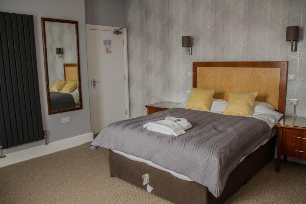 een slaapkamer met een groot bed en handdoeken bij Keld Green House in Seascale