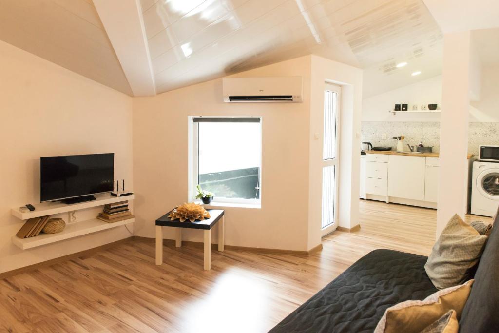 a living room with a couch and a television at Balabanov White in Varna City