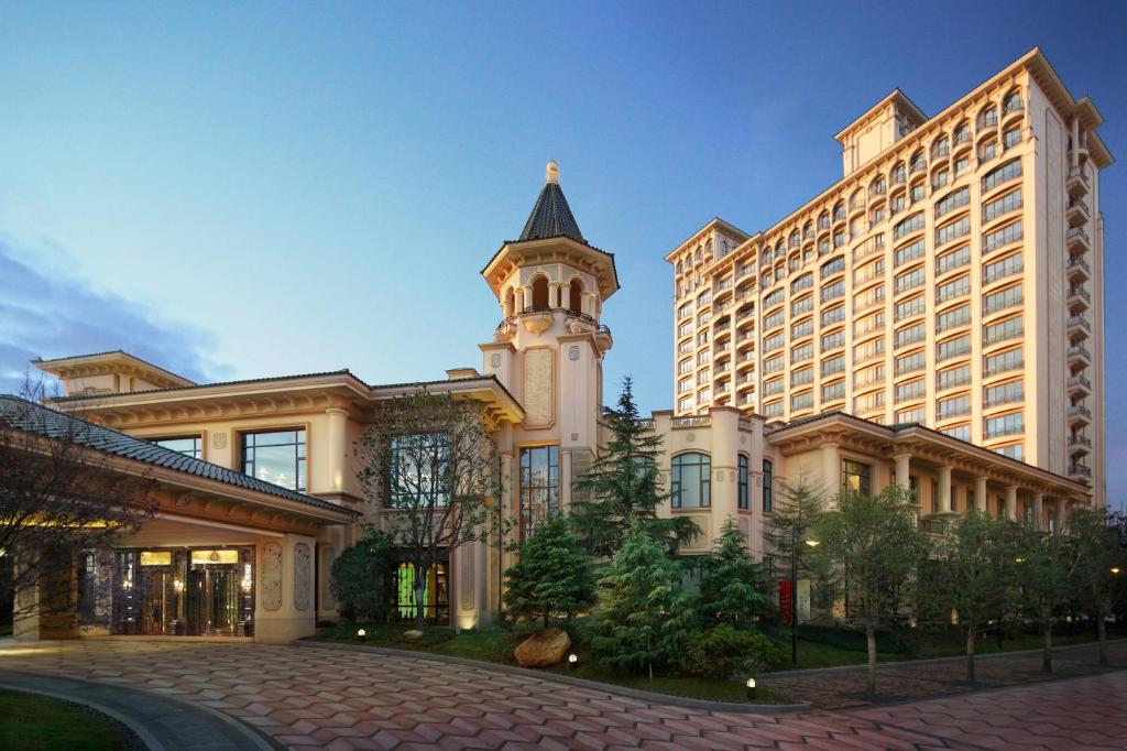 un gran edificio con una torre de reloj delante de él en Chateau Star River Pudong Shanghai en Shanghái