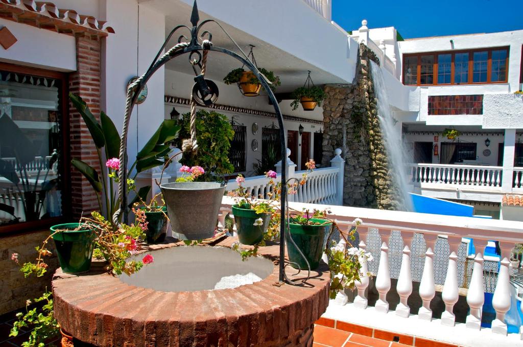 une souche d'arbre avec des plantes en pot sur un balcon dans l'établissement Hotel Las Rampas, à Fuengirola