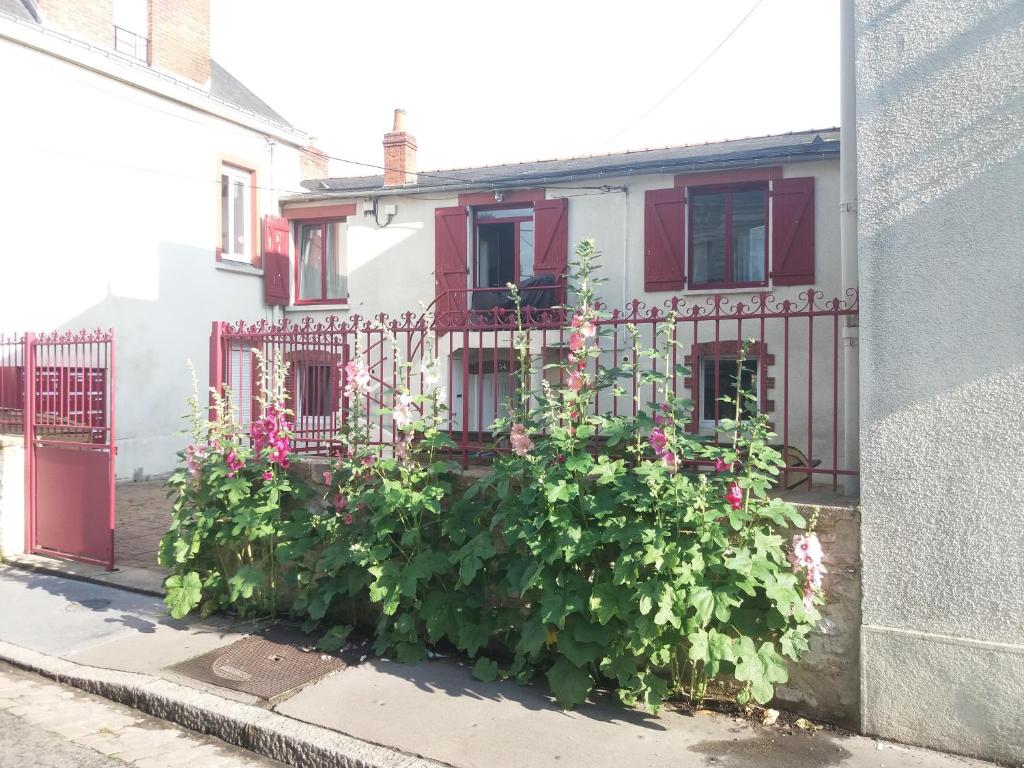 a house with a fence with flowers in front of it at Chambres Zola in Nantes