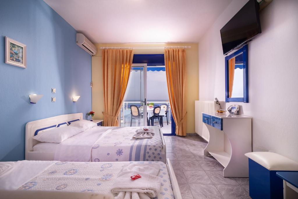 a bedroom with two beds and a view of the ocean at House Katerina Mediterranean in Sarti