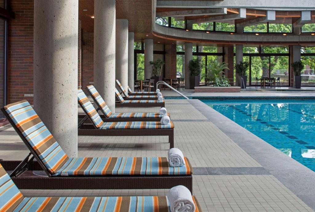 a row of lounge chairs next to a swimming pool at Hyatt Lodge Oak Brook Chicago in Oak Brook