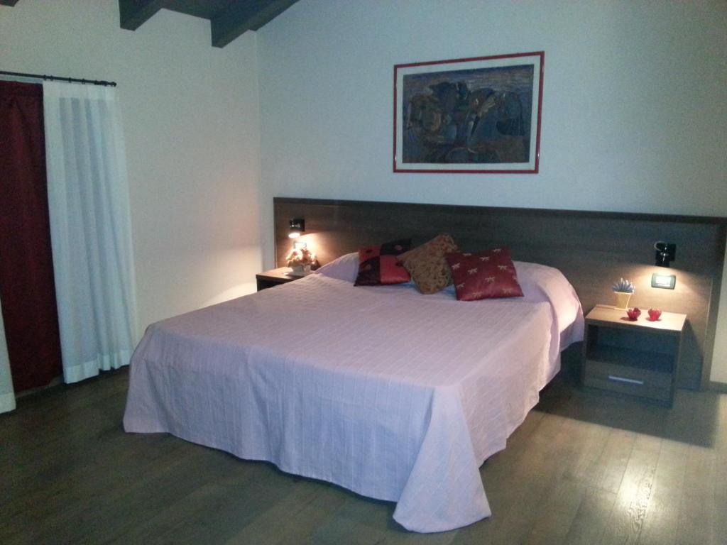 sypialnia z dużym białym łóżkiem i dwoma stolikami w obiekcie Hotel La Vecchia Reggio w mieście Reggio nell'Emilia