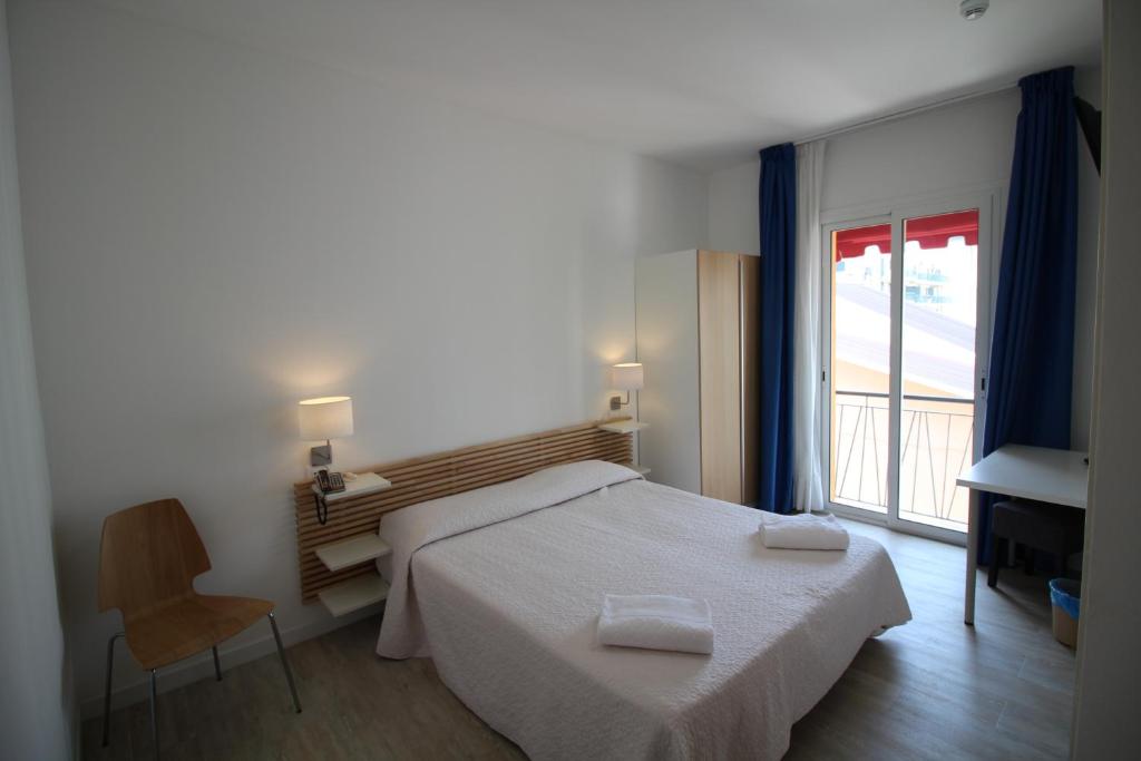a bedroom with a bed and a large window at Hotel Rex in Caorle