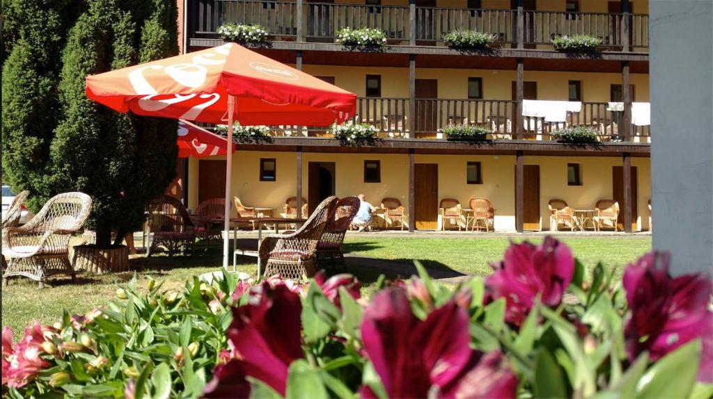 a patio with chairs and an umbrella and a building at Dom Wczasowy Dorja in Jastarnia