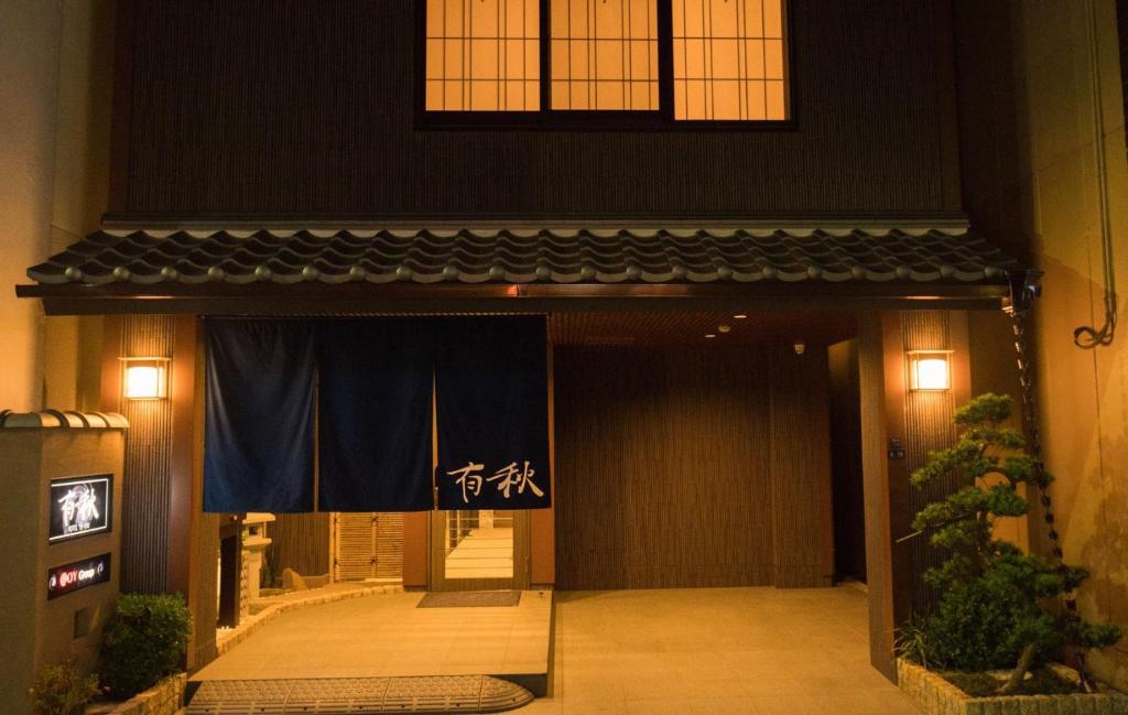 een voordeur van een gebouw met een blauw gordijn bij Hotel Yu-shu in Osaka