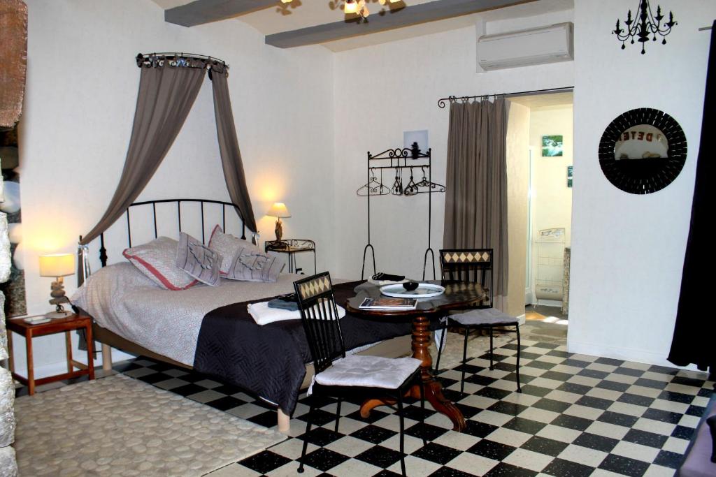 Saint Alban AuriollesにあるMas Des Falaisesのベッドルーム1室(ベッド1台、テーブル、椅子付)
