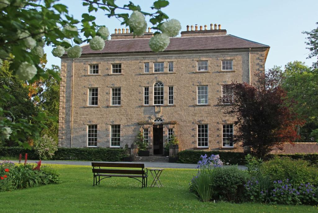 a bench in front of a large brick building at Coopershill House in Riverstown