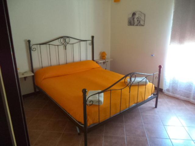 una camera con un letto e una coperta arancione di CASA DELL'ARCO a Calatafimi