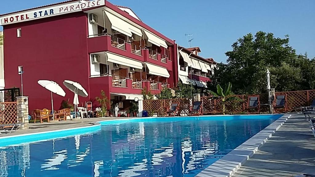 un hôtel avec une piscine en face d'un bâtiment dans l'établissement Star Paradise, à Neos Marmaras