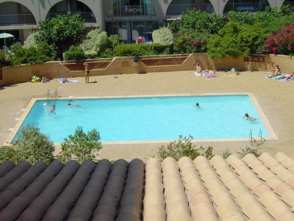 un groupe de personnes nageant dans une piscine dans l'établissement Cap Soleil T3 proche plage, au Cap d'Agde