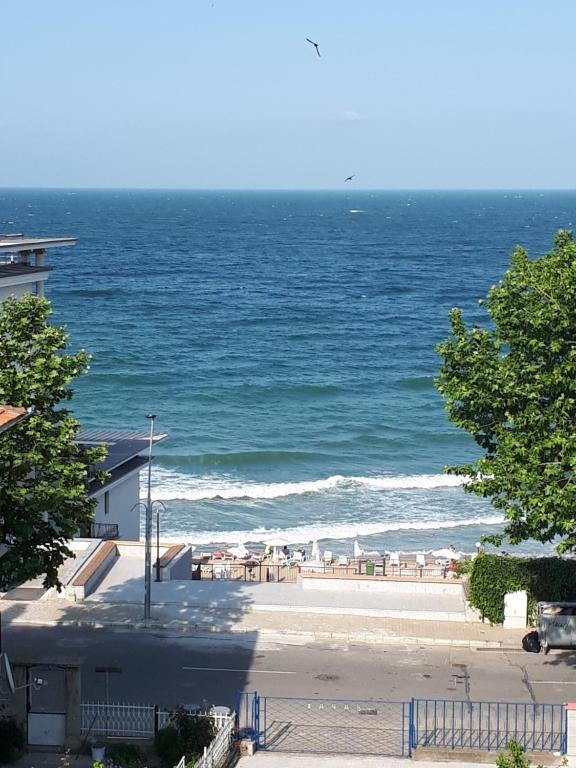 a view of the ocean with a beach with chairs at Blue House - Синята къща in Obzor