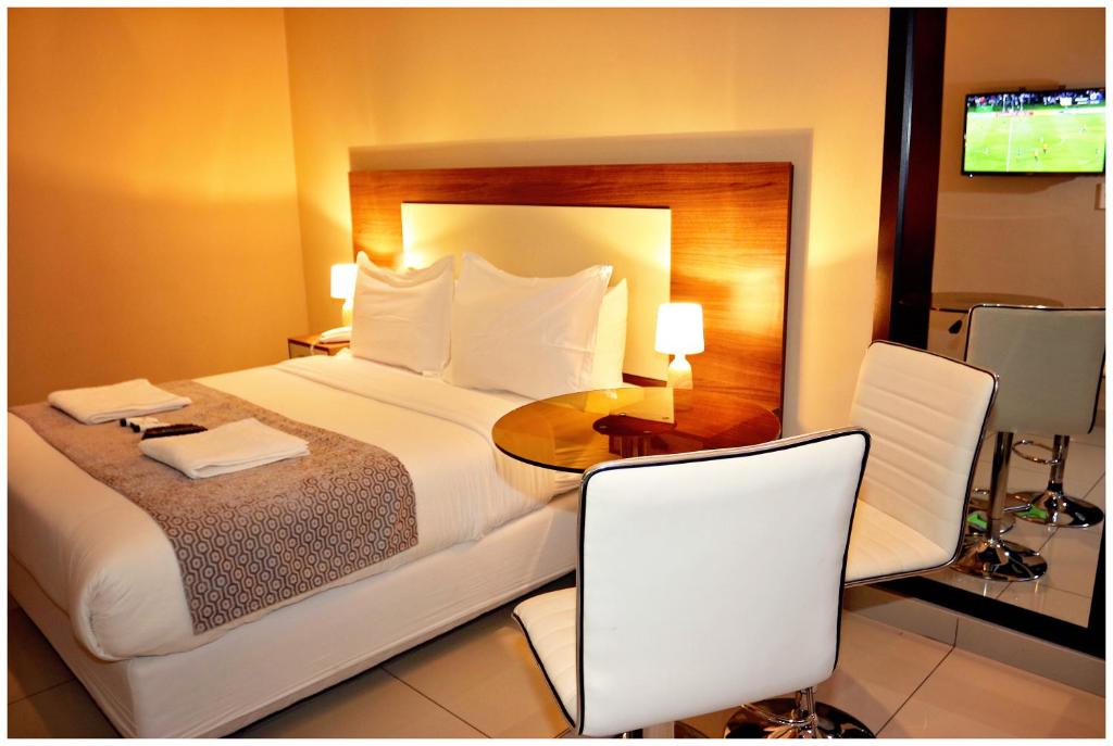 a hotel room with a bed and a table and chairs at Eagle Nest Luxury Accommodation in Roodepoort