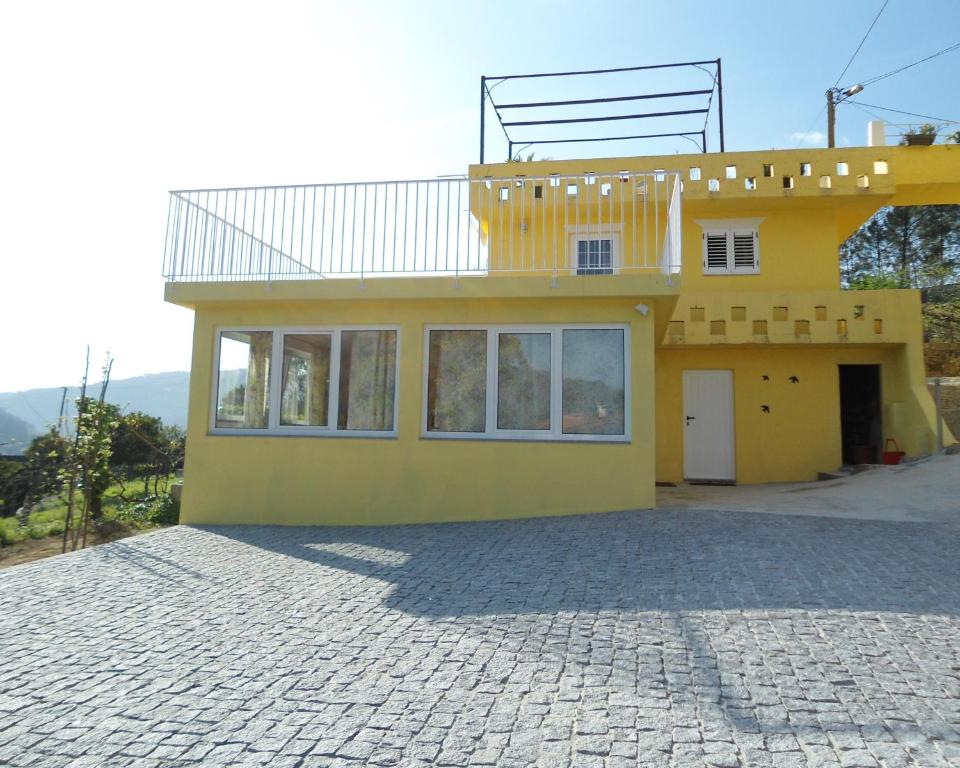 a yellow house with a balcony on top of it at Casa Amarela - Região do Douro in Loureiro