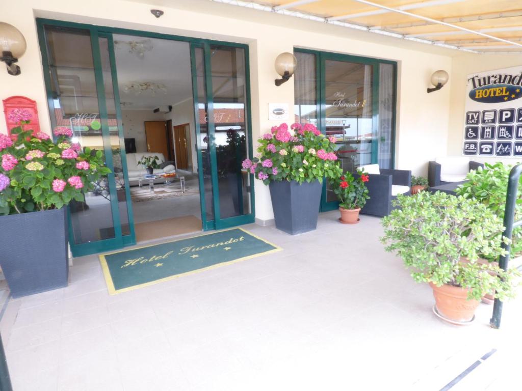 a store front with potted plants in front of it at Hotel Turandot in Torre del Lago Puccini