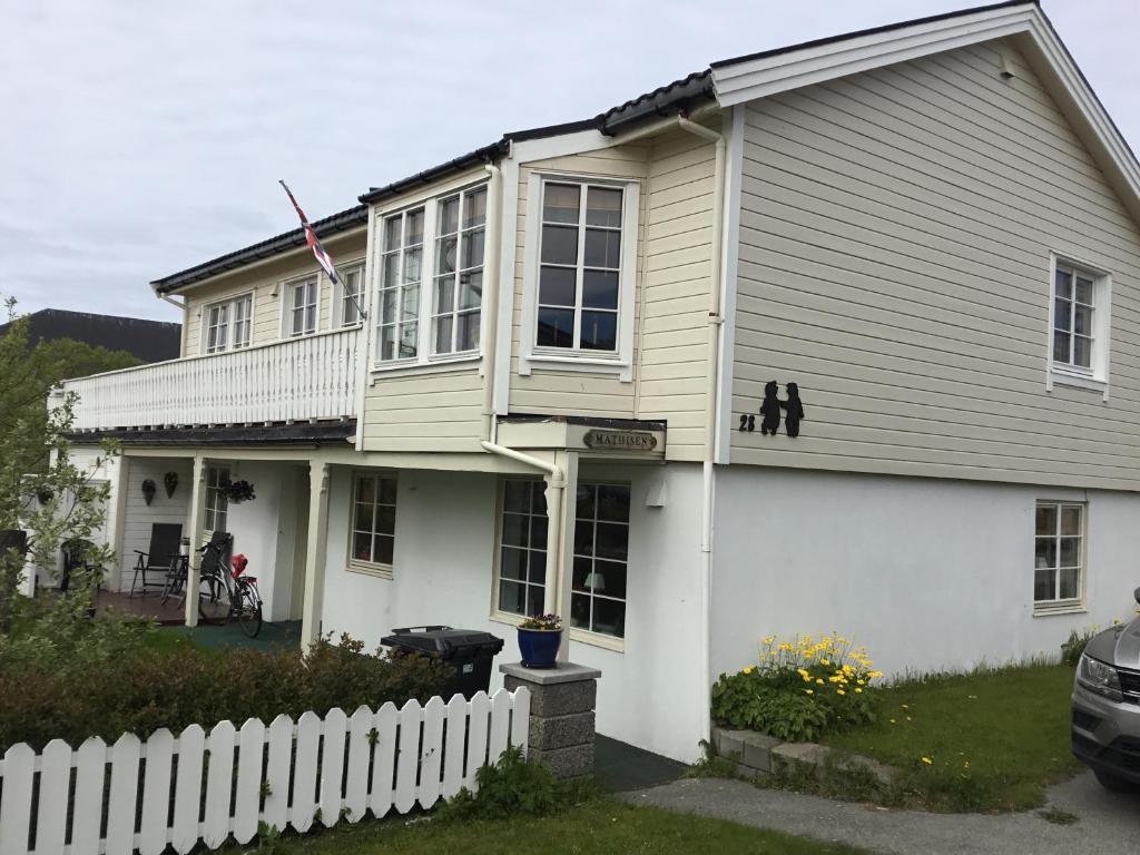 a white house with a white fence in front of it at Kong Hans gt. 28 in Andenes