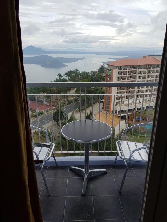 balcón con mesa, sillas y vistas en Milagrosa(SMDC wind residences), en Tagaytay