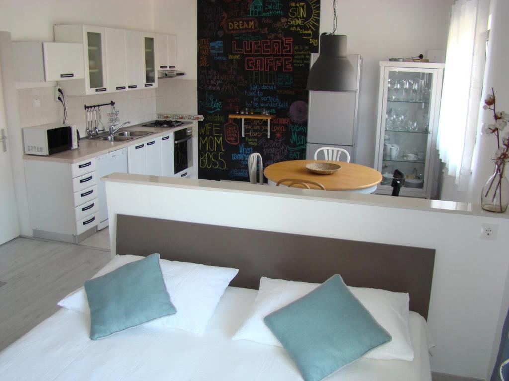 トゥチェピにあるApartment Lukaのベッドルーム1室(ベッド1台付)、キッチン(テーブル付)