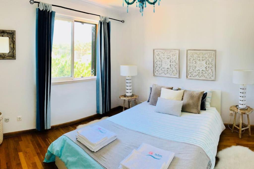 a bedroom with a large bed with a window at Sea Breeze Golf & Beach Villa in Charneca