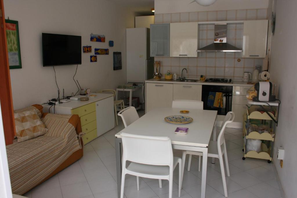 a kitchen with a white table and chairs and a couch at Casa Del Mulino in San Vito lo Capo