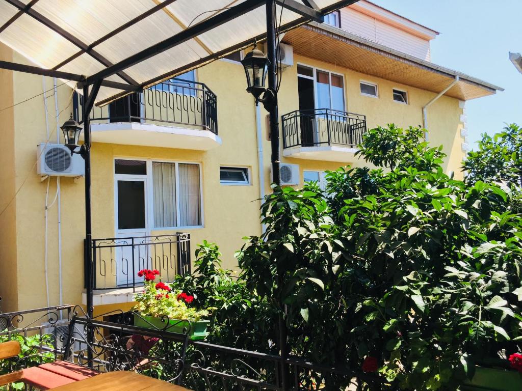 an outdoor patio with a pergola in front of a building at Mandarinoviy Sad in Gagra