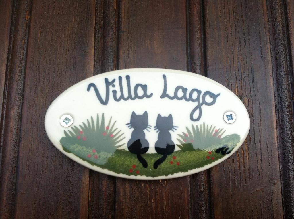 een bord op een houten deur met twee katten bij Residence Spighetta 2 in Torri del Benaco