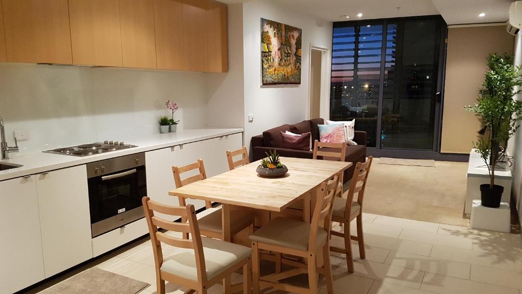 kuchnia i jadalnia z drewnianym stołem i krzesłami w obiekcie 2BEDS Melbourne Central|Crown Casino|Colin|S Cross w Melbourne