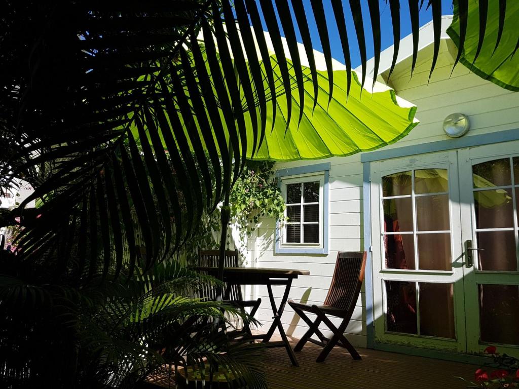 un patio con tavolo e sedie su una casa di Bungalow meublé près du lagon a La Saline Le Bains