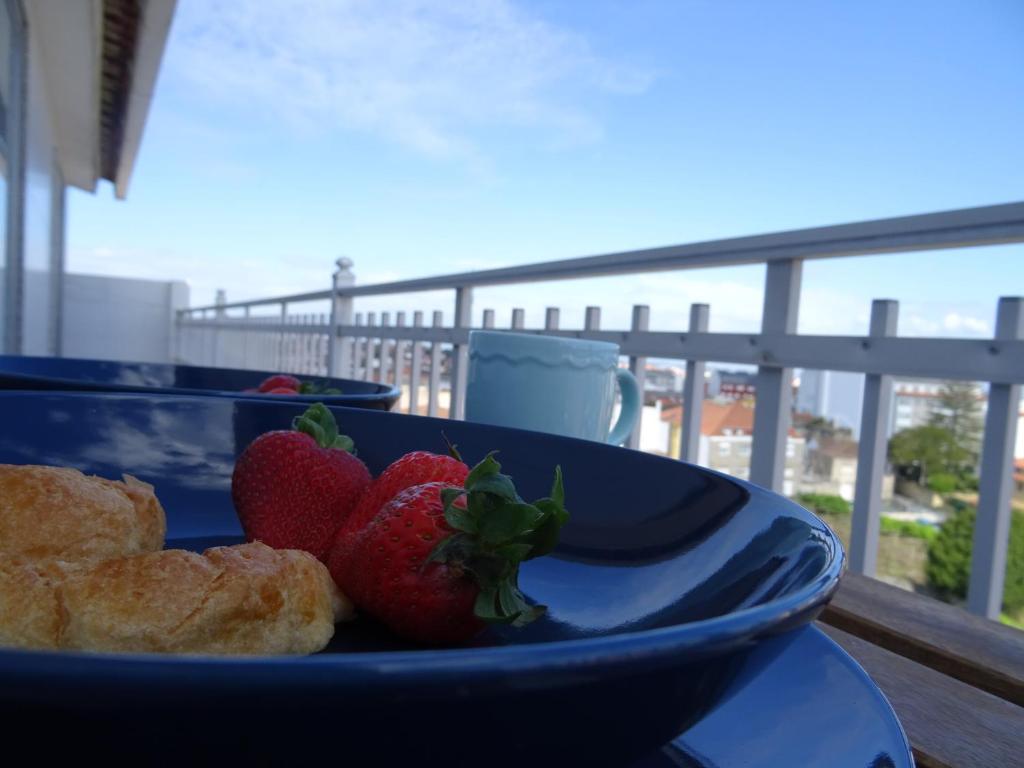 a blue plate with strawberries on a balcony at Apartamento en O Grove in O Grove