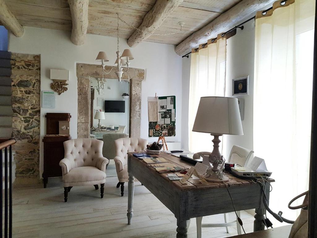 a room with a desk and chairs and a mirror at La Casa della Filanda in Belmonte Calabro