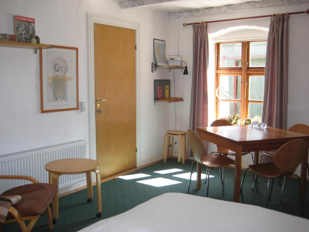 een kamer met een tafel en stoelen en een raam bij Farmer Annekset Ravning in Bredsten