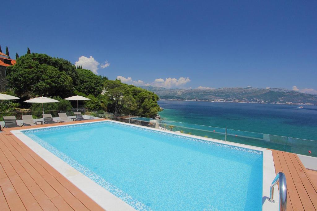 a swimming pool with a view of the water at Kalamota Beach House in Koločep