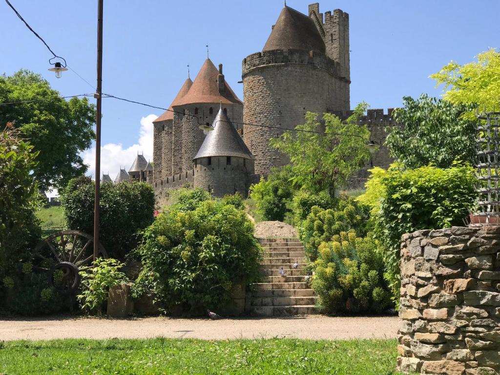 a castle with turrets and stairs in a garden at La Rapière in Carcassonne