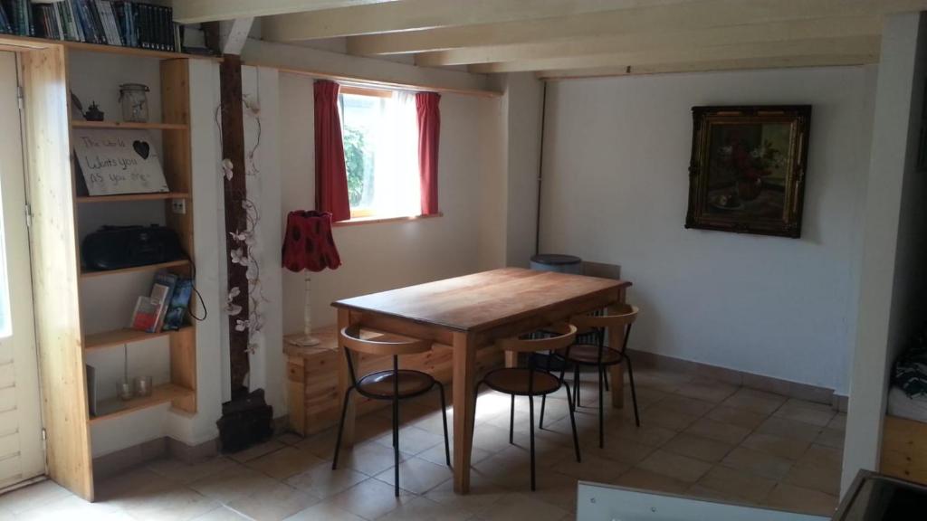 uma sala de jantar com uma mesa de madeira e cadeiras em studio-appartement in paardenstal em Colijnsplaat