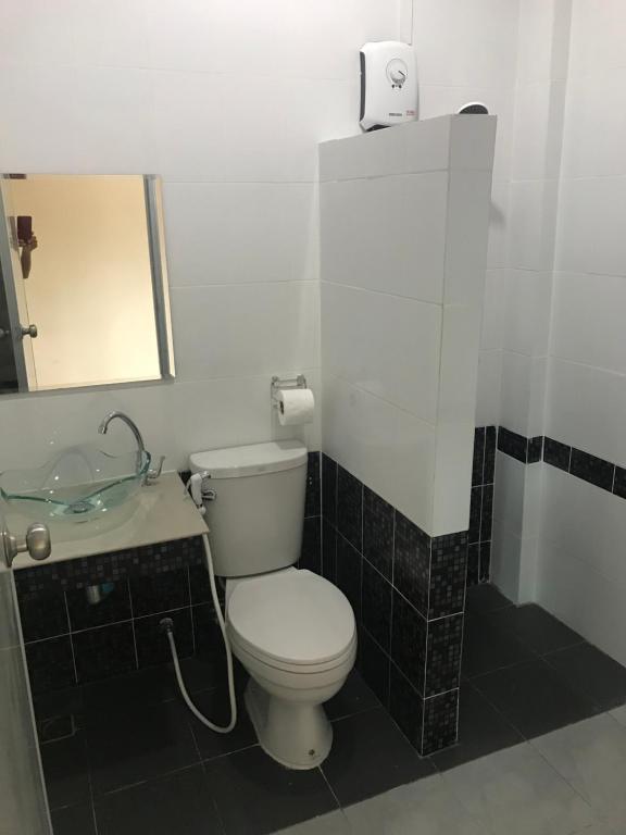 a bathroom with a toilet and a sink and a mirror at Baan Bon Resort Bang Tabun in Phetchaburi