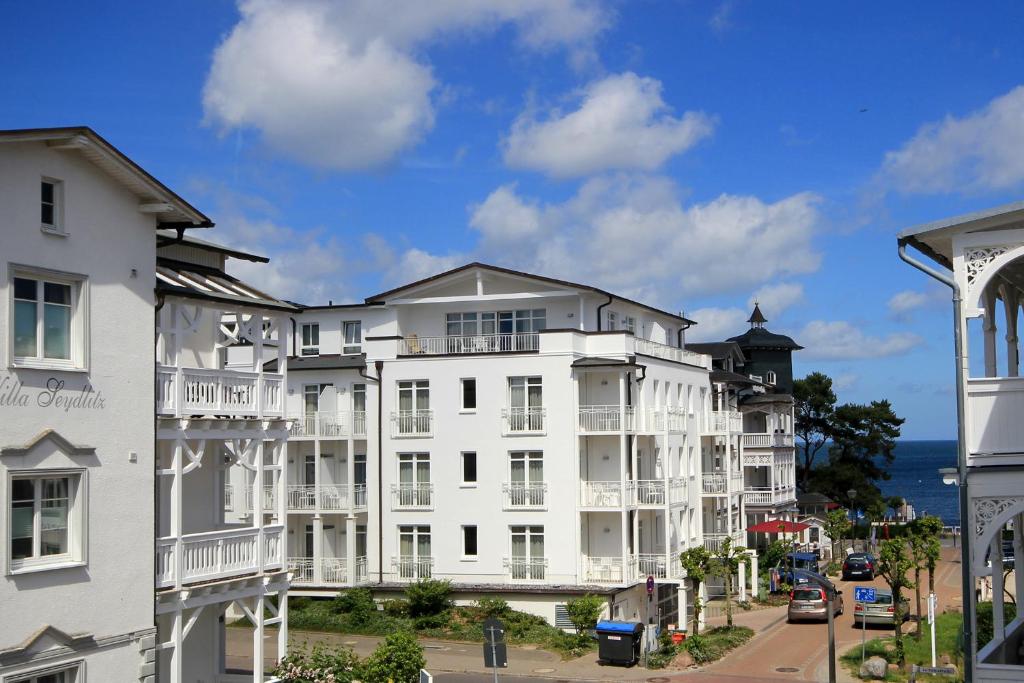 eine Reihe von weißen Apartmenthäusern auf einer Straße in der Unterkunft Haus & Villa Concordia by Rujana in Binz