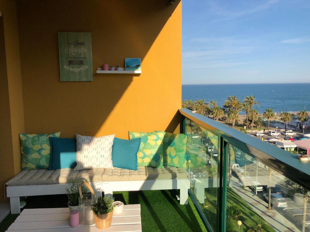 balcón con sofá y vistas al océano en Luxury Apartment Bajondillo Beachfront, en Torremolinos