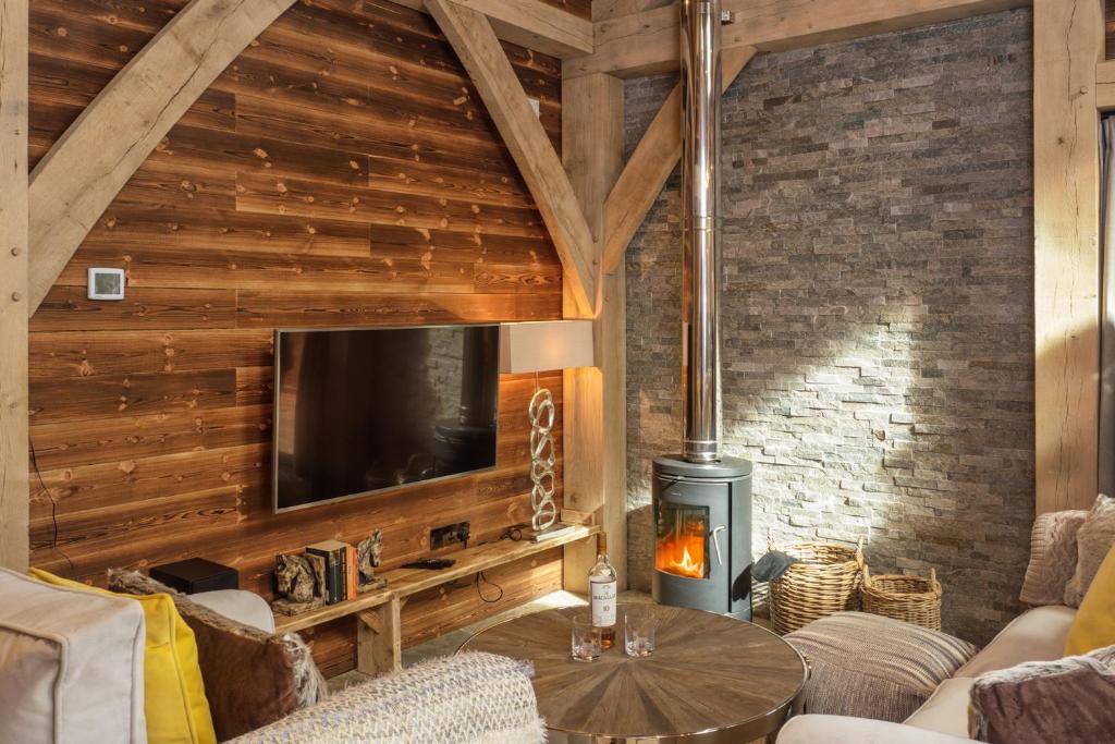 uma sala de estar com uma televisão e uma parede de madeira em Macdui Lodge em Aviemore