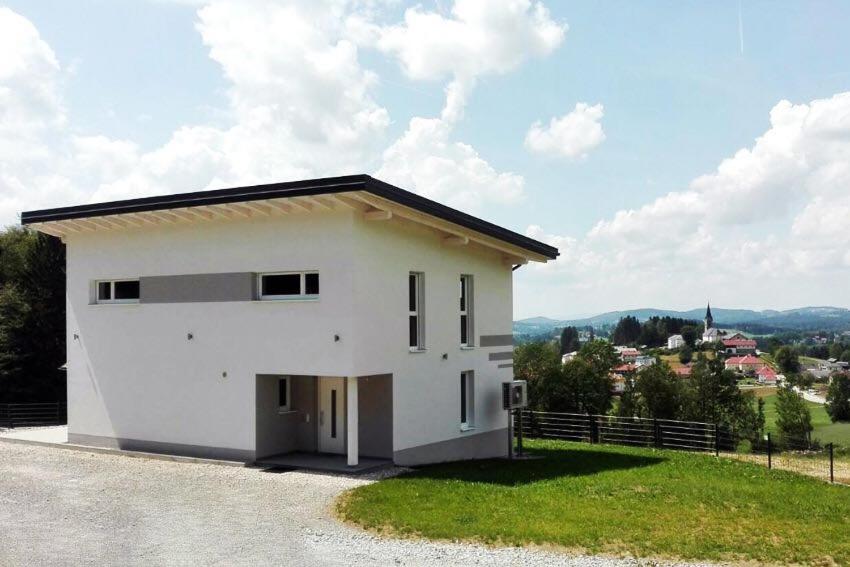 una piccola casa bianca con vista su una città di Ferienhaus Grobauer II a Schwarzenberg am Bohmerwald