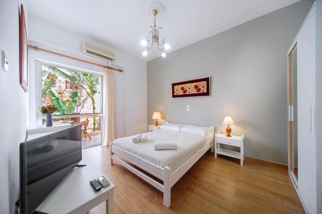 a bedroom with a bed and a tv and a window at Casa Kasteli in Chania Town