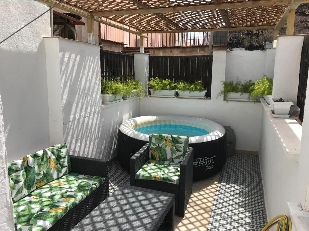 a patio with a hot tub and two chairs at Atico En El Centro in Valencia